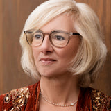 Frau mit blonden Haaren trägt die Hypreader Lupus Champagner Brille, mit schwarzen Bügel, stilvolle Nahaufnahme mit warmem Hintergrund