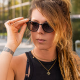 Frau mit Dreadlocks trägt die Lupus Unisex Sonnenbrille in Schwarz von Hypreader – stilvoller, urbaner Look bei Tageslicht
