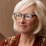 Ältere Frau mit blondem Haar trägt Hypreader Taurus schwarze Lesebrille mit schwarzer runder Front und havannafarbenen Bügeln.