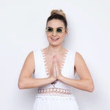 Frau mit Dutt und weißem Sommerkleid trägt die Hypreader Sonnenbrille Vela in Neon-Gelb mit blauen Verlaufsgläsern vor weißem Hintergrund