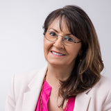 Frau mit dunklem Haar und rosa Blazer trägt die Hypreader Gemini Blaulichtfilterbrille in grau