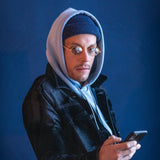 Model trägt Hypreader Gemini ovale Sonnenbrille in Orange – auffälliger Streetstyle-Look mit Kapuzenpullover und Beanie.