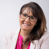 Frau mit Hypreader Leo Lesebrille in Blau, freundlich lächelnd mit rosa Blazer und pinker Bluse – Porträtaufnahme