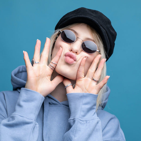 Junge Frau mit Kussmund trägt Sonnenbrille Gemini in Silber mit grauen Gläser