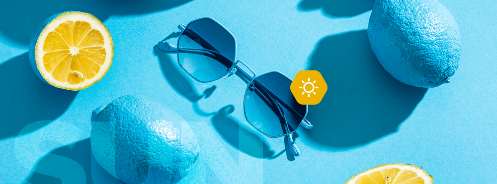 Hypreader Aquila Sonnenbrille in Blau mit blauen Gläsern liegt zwischen Zitronen auf blauem Hintergrund – sommerlicher Header mit frischer Farbwelt