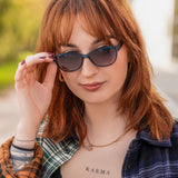 Hypreader Pyxis in petrol wird von einer jungen Frau mit rötlichen Haaren getragen. Die Sonnenbrille ergänzt ihren Alltagslook auf stilvolle Weise und bietet gleichzeitig angenehmen Sonnenschutz.