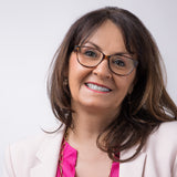 Ältere Dame mit braunem Harr trägt braune Blaulichtlesebrille Pyxis in braun und lächelt in die Kamera