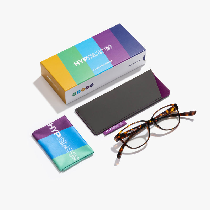Komplettansicht der Hypreader Pyxis Brille in braun – enthalten sind Blaulichtfilterbrille, Sonnenclip, Etui und Reinigungstuch.