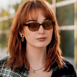 Junge Frau trägt die Hypreader Sonnenbrille Pyxis Braun bei Sonnenlicht draußen, modernes Styling.