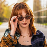 Junge Frau mit Hypreader Pyxis Brille und Sonnenclip Braun im urbanen Outdoor-Setting – stylisch, modern und sonnen­geschützt.