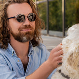 Mann trägt Hypreader Taurus in Gunmetal  Brille mit Sonnenclip und genießt den Moment mit einem Hund