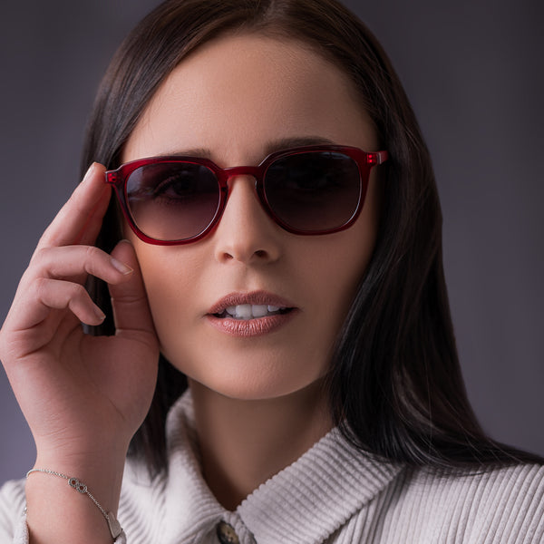 Eine Frau trägt die Hypreader Orion Sonnenbrille in Rot mit grauen Gläsern in einem Studioporträt