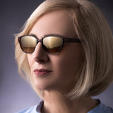 Ältere Frau mit der Hypreader Sonnenbrille Pyxis in Braun, aufgenommen im Studio mit Fokus auf Gesicht und Brille.